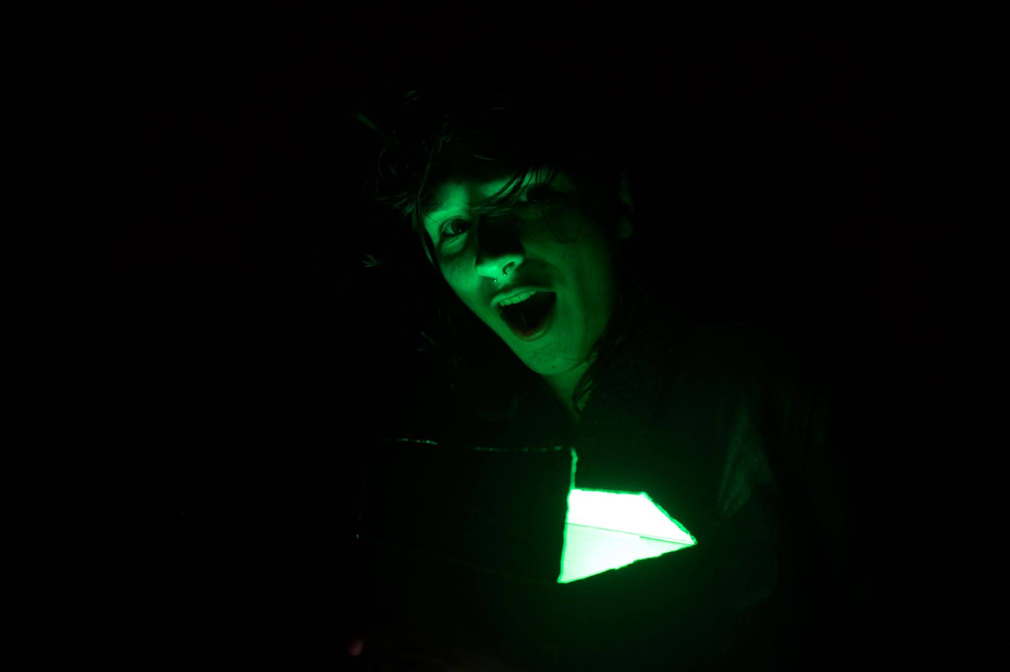 A man's face illuminated by green light