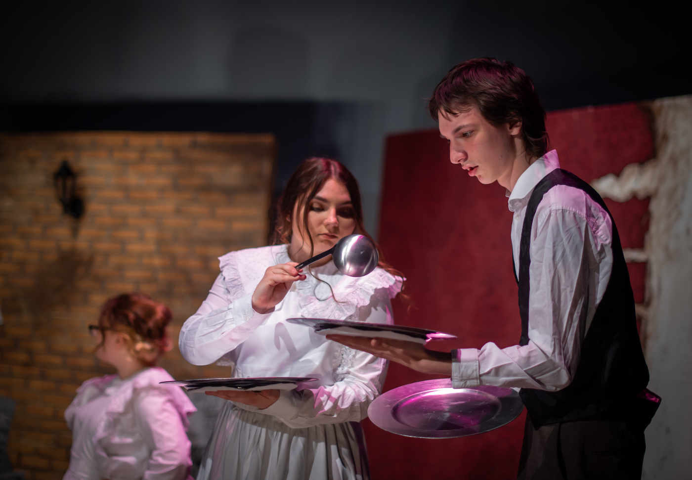 A man recieving a ladle of food from a woman