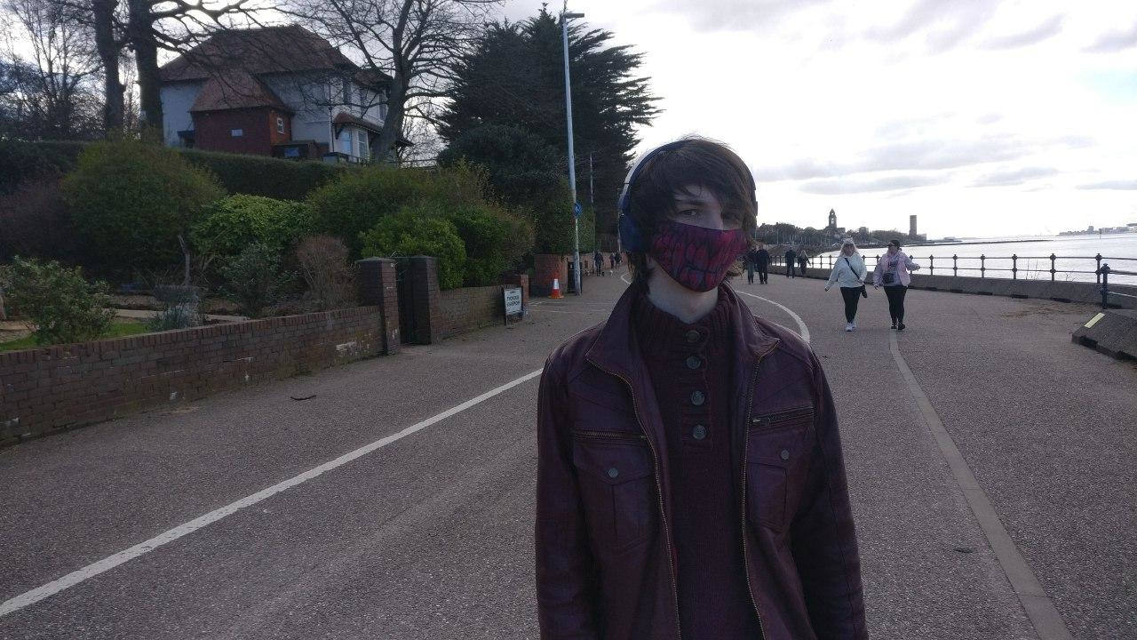 A man wearing a mask on a promenade