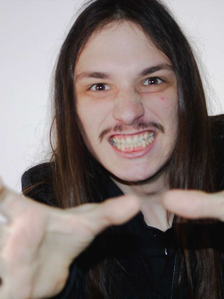 A man seen from the from with his hands grasping menacingly