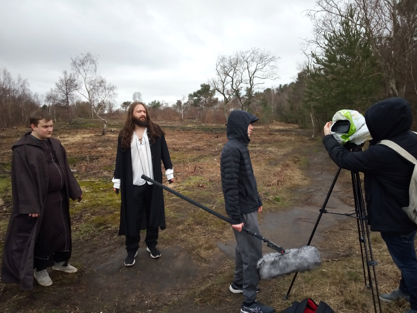 Two actors and two crew filming outdoors 