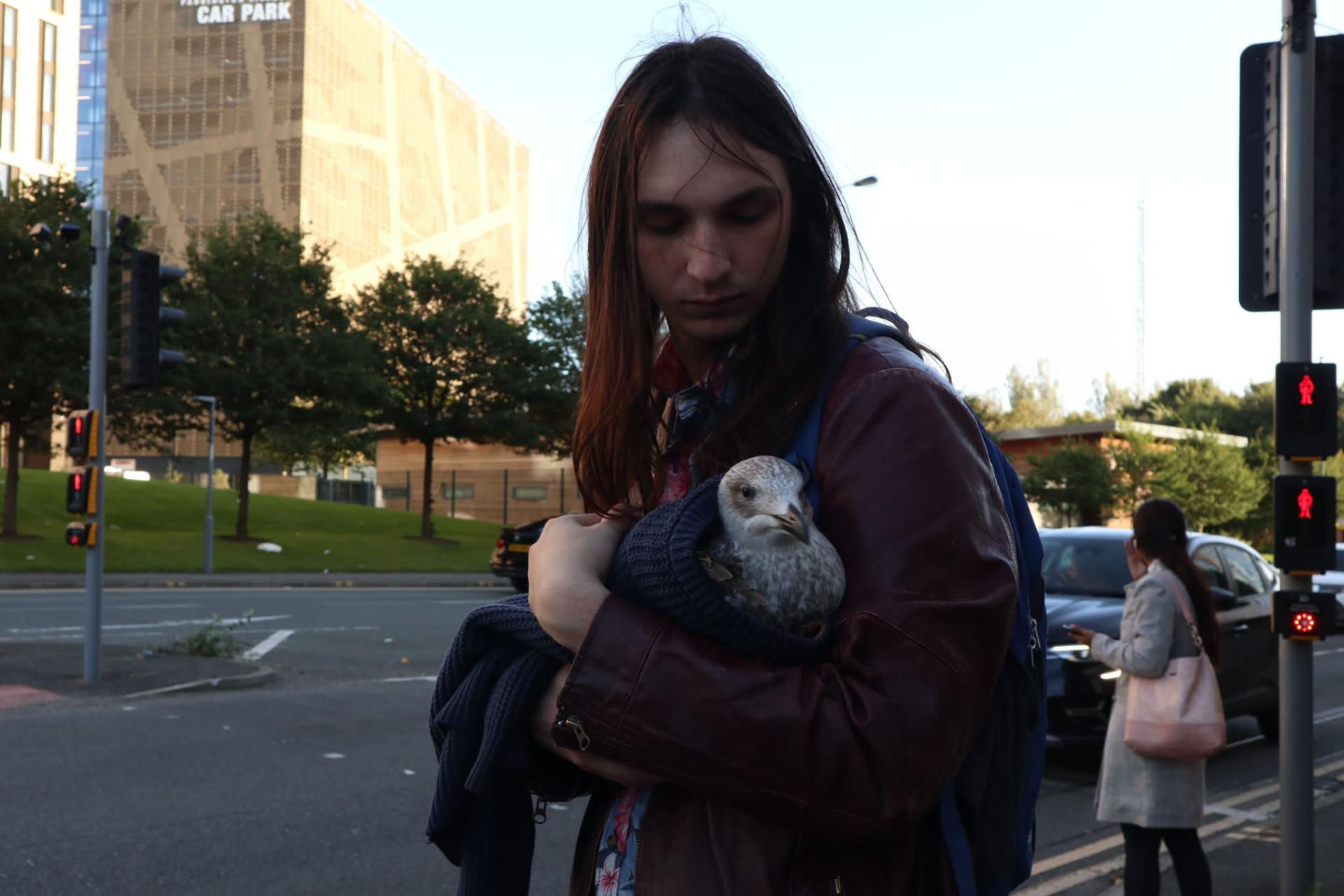 Joseph cradling a seagull in his arms